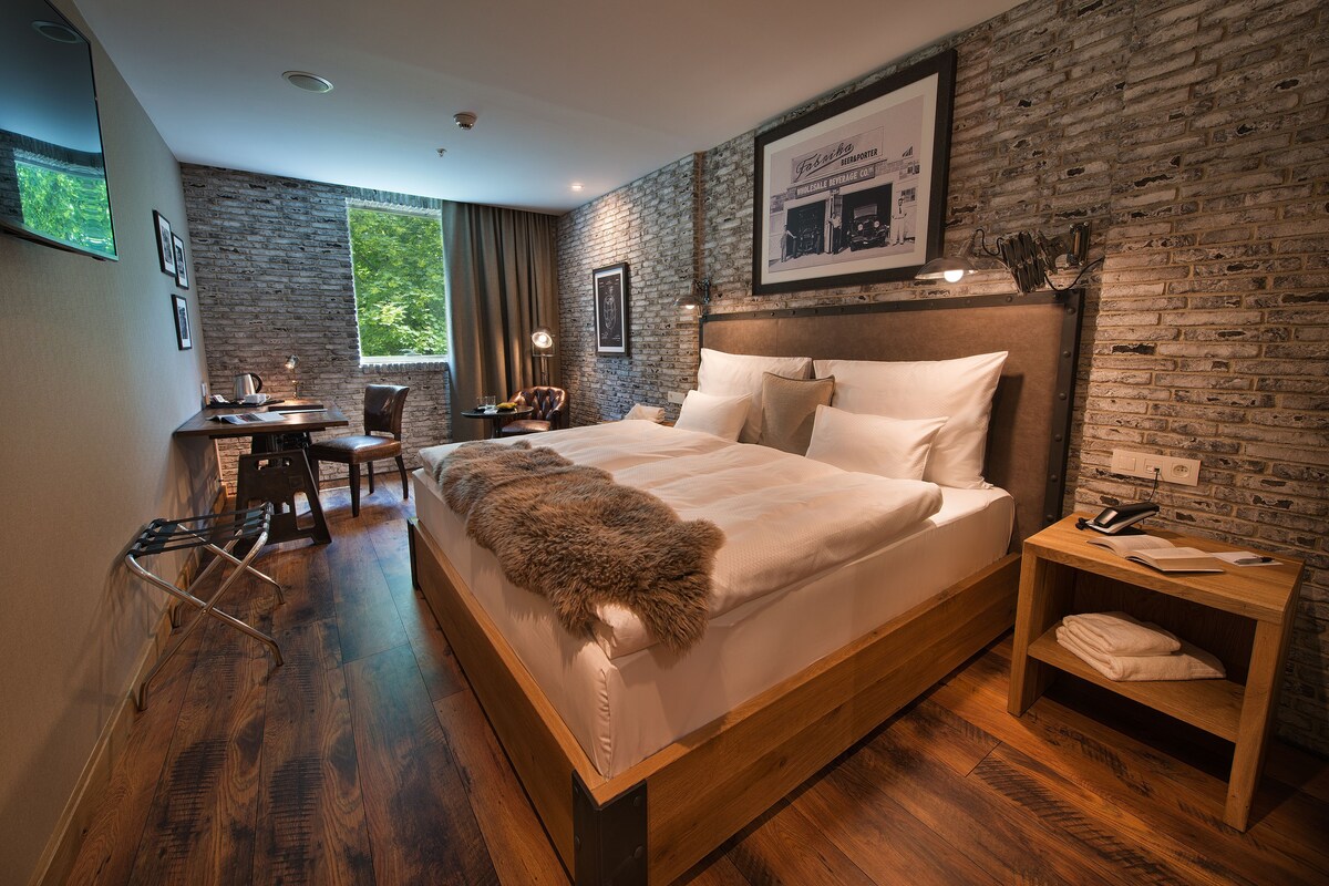 A modern bedroom with a large bed, a desk, and a chair.