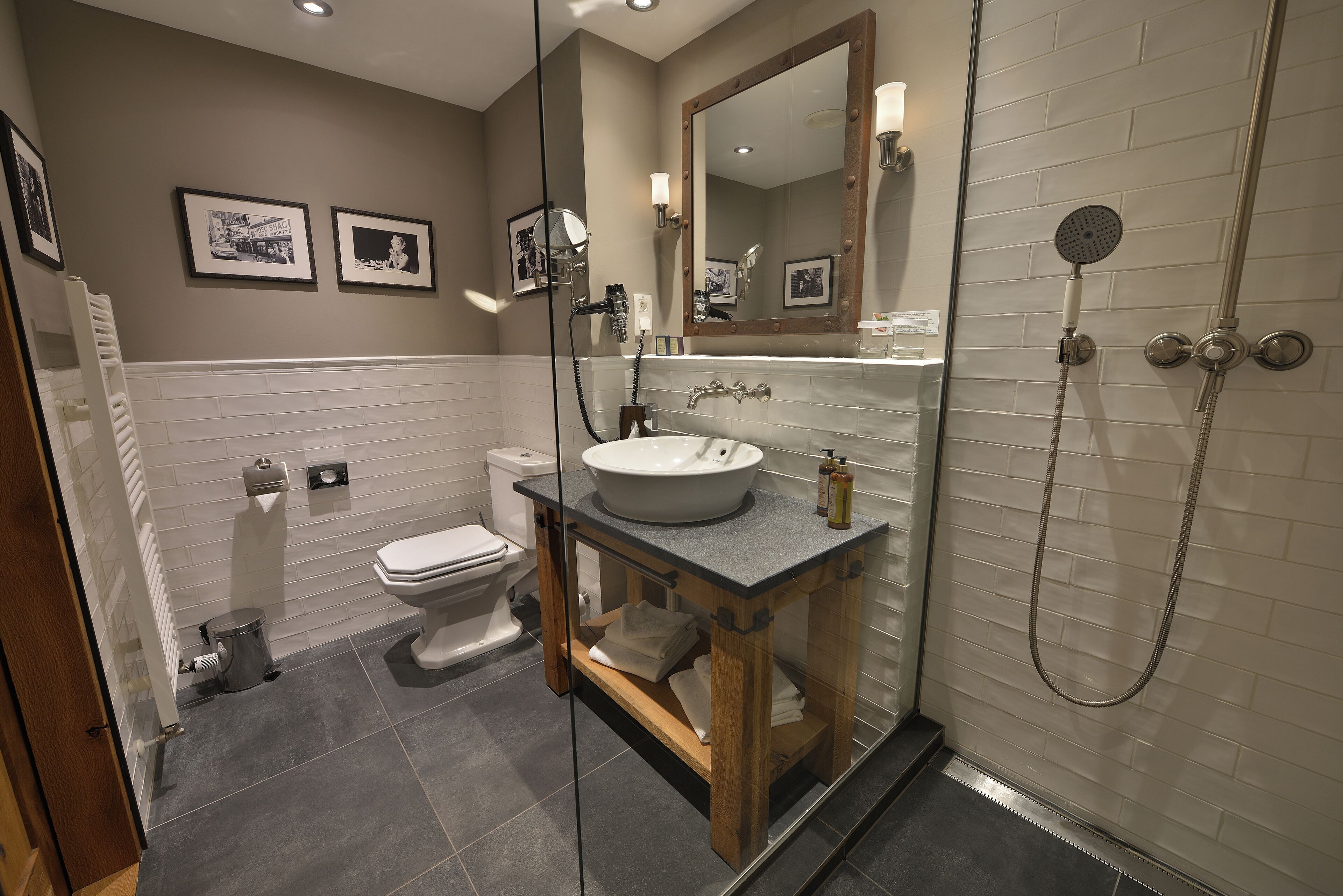 A modern bathroom with a large mirror, a sink, and a shower.