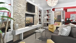Una sala de estar moderna con chimenea de piedra, un televisor de pantalla plana y un letrero de BISTRO-BAR.