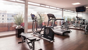 A gym with various exercise equipment, large windows, and a television. - Best Western Plus 93 Park Hotel (Bogotá)