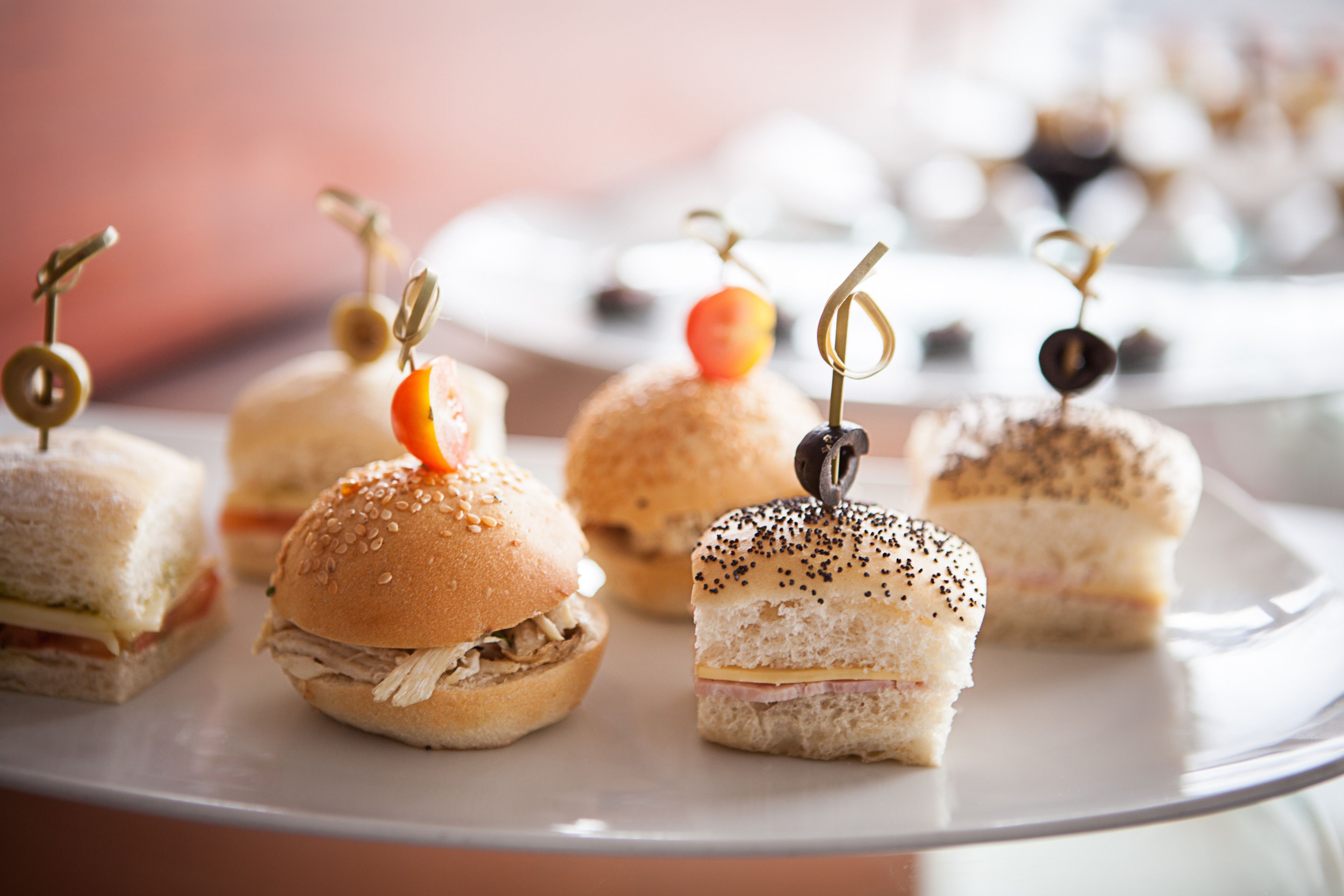 Eine Platte mit Mini-Sandwiches, verschiedenen Belägen und Garnituren.