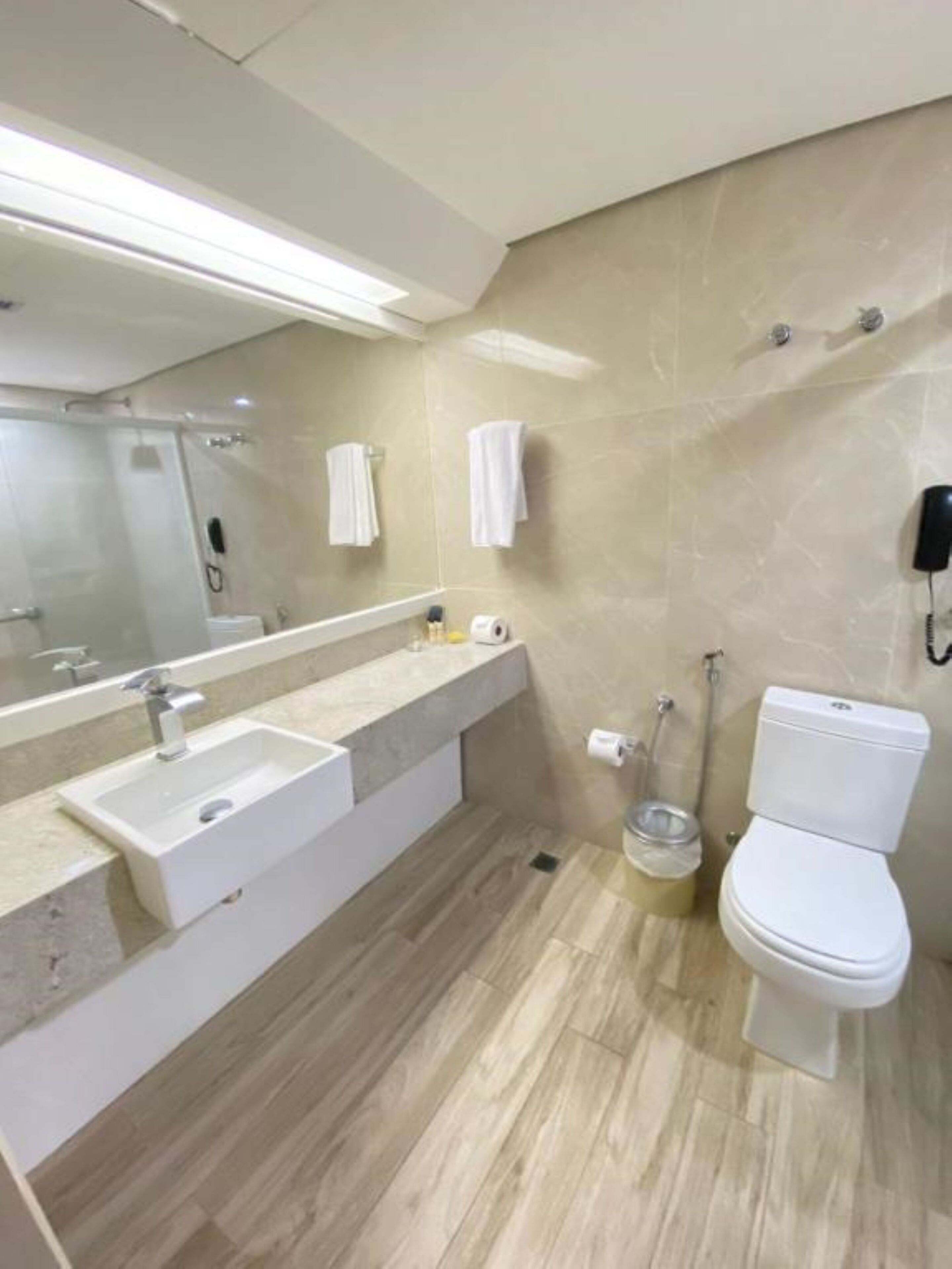 Een moderne badkamer met een wastafel, spiegel en toilet.