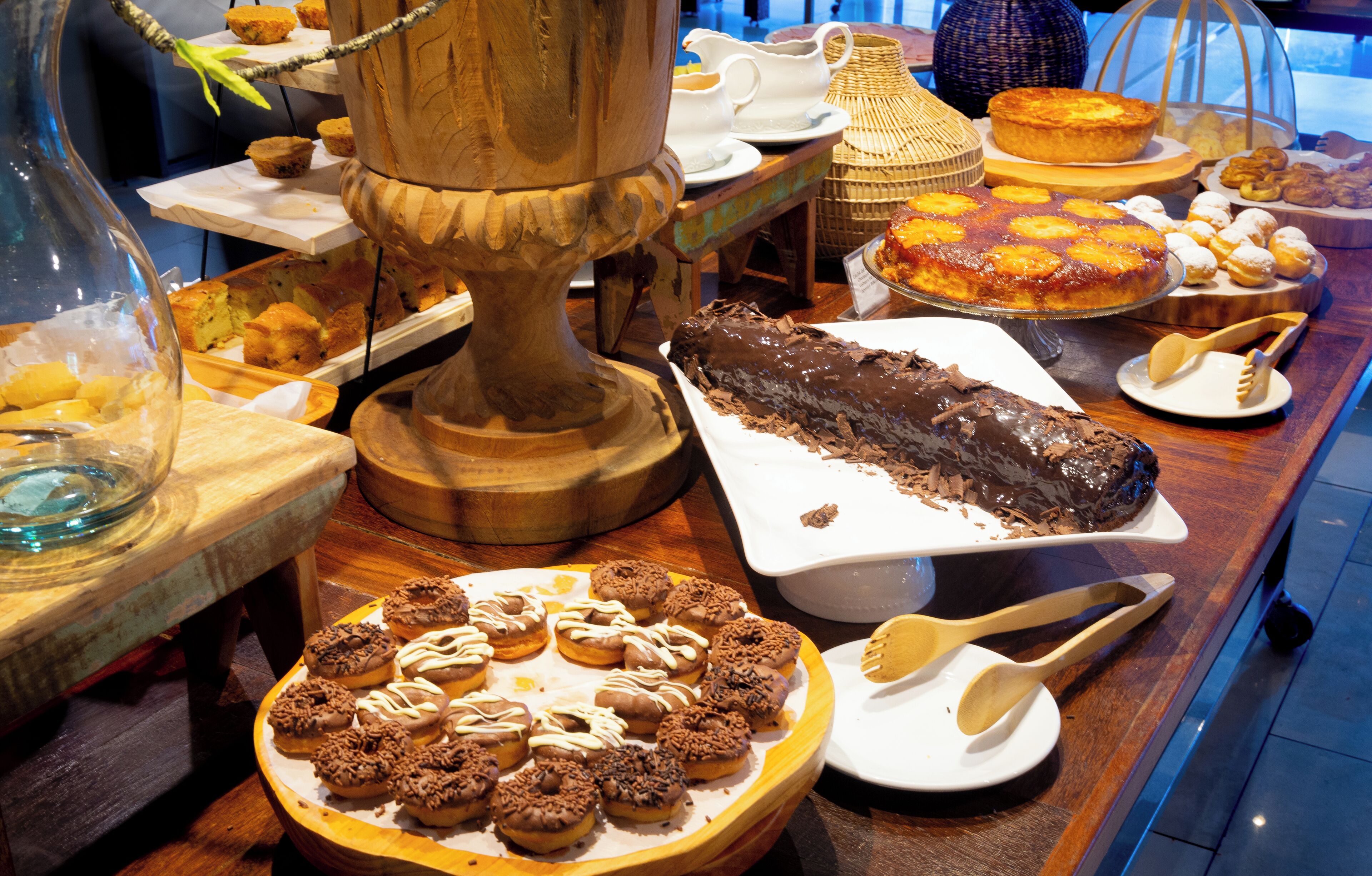 Un bufé con diversos postres, entre ellos pasteles, repostería y un pastel de chocolate.