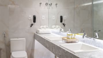 Ein modernes Badezimmer mit Waschtisch aus Marmor, Toilette und Dusche.