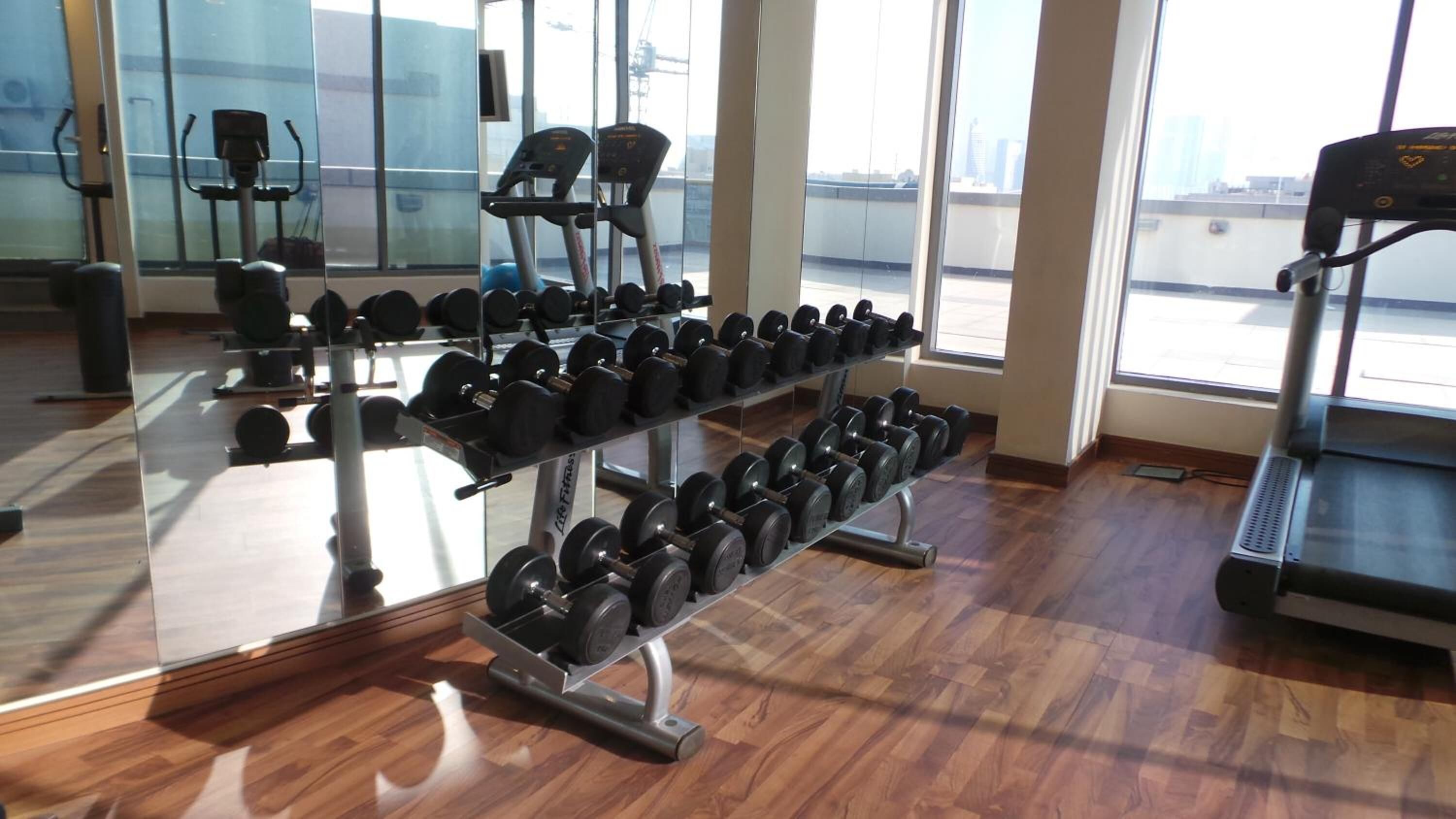 A gym with weightlifting equipment and treadmills.