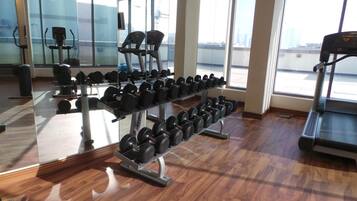 A gym with weightlifting equipment and treadmills.