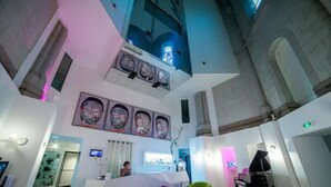 Un interno moderno con una reception, posti a sedere colorati e un pianoforte.