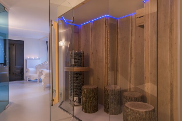 A modern interior with a glass partition, wooden paneling, and a staircase.