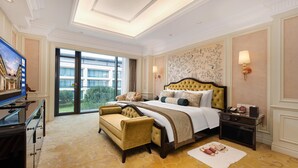 A spacious hotel room with a large bed, a sofa, a TV, and a view of the outside. - WorldHotel Grand Juna Wuxi (Wuxi)