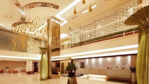 A spacious lobby with a high ceiling, modern lighting fixtures, and a decorative glass partition. - Mercure Padang (Padang)