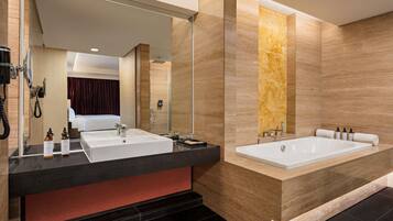 Un baño moderno con dos lavamanos, una bañera grande y un espejo.
