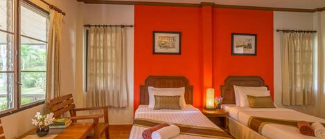 Une chambre d’hôtel avec deux lits, un bureau en bois et une chaise.
