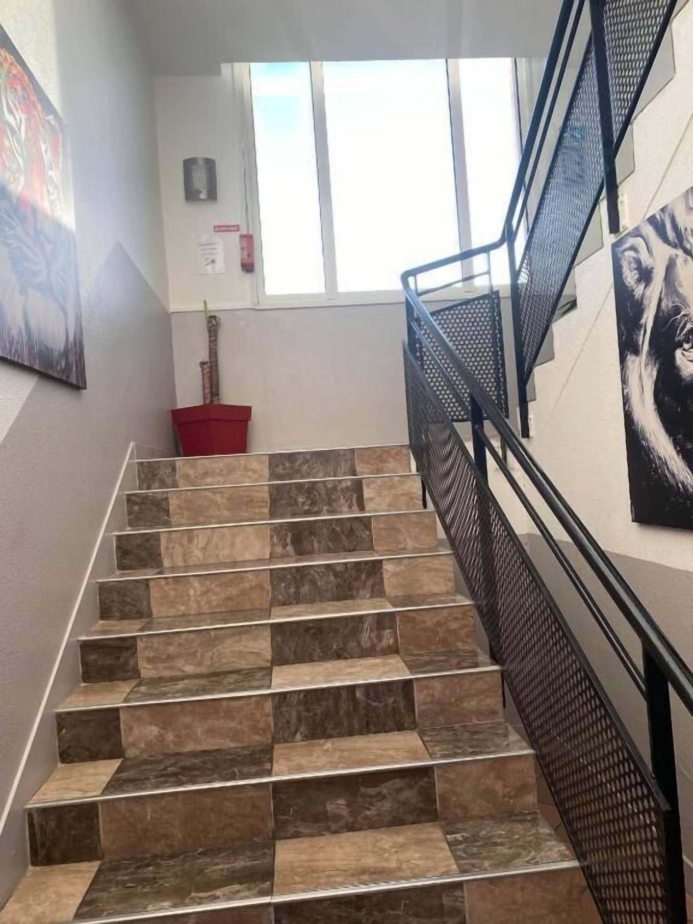 A staircase with alternating dark and light tiles leading to an upper floor.