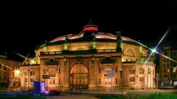 A historic building with a large central dome, arched windows, and a prominent entrance.