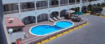 A pool area with lounge chairs and umbrellas on a cruise ship deck.