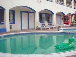 Un hotel con piscina que incluye una tortuga hinchable verde.