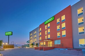 A modern hotel building with a prominent sign for 'City Express' and a large glass entrance. - City Express Junior by Marriott Guadalajara Periférico Sur (Tlaquepaque)
