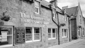 A stone building with signs advertising The Commercial, a pub, lounge bar, and beer garden. - The Commercial Hotel (Aboyne)