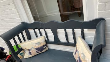 Sit comfortably on this bench with a vintage flair, featuring a curved backrest and armrests.
