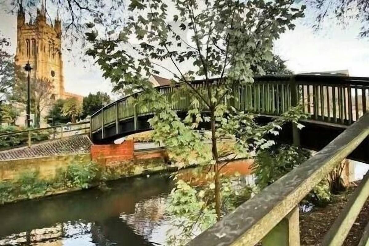 Un pont enjambant une rivière, avec un bâtiment historique en arrière-plan.