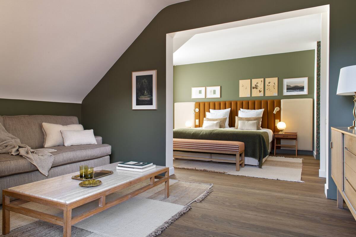 Een gezellige slaapkamer met een bed, nachtkastje en een bank in een modern appartement.