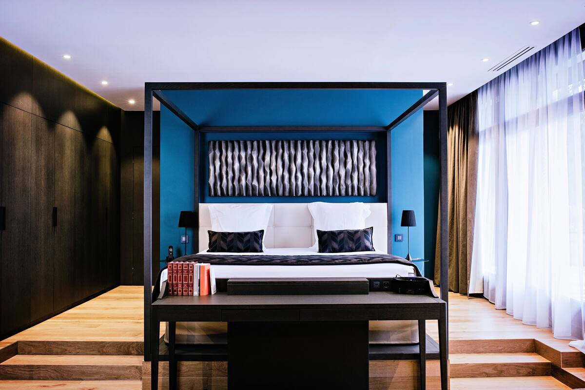 Een moderne slaapkamer met een bed, nachtkastjes en een bedtafel.