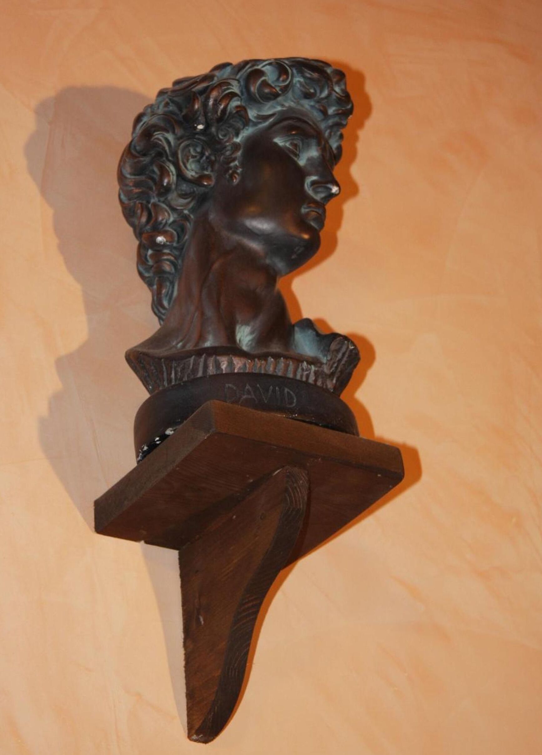 A wooden sculpture of a bust with the name "DAVID" on it.