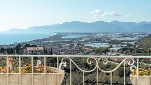 A balcony with a view of a coastal town, mountains, and a body of water. - Belvedere Sperlonga (Sperlonga)