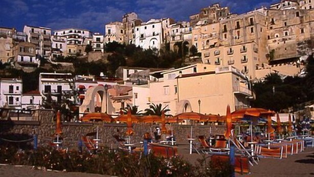 A coastal town with terraced buildings, outdoor seating, and a clear sky. - Belvedere Sperlonga (Sperlonga)