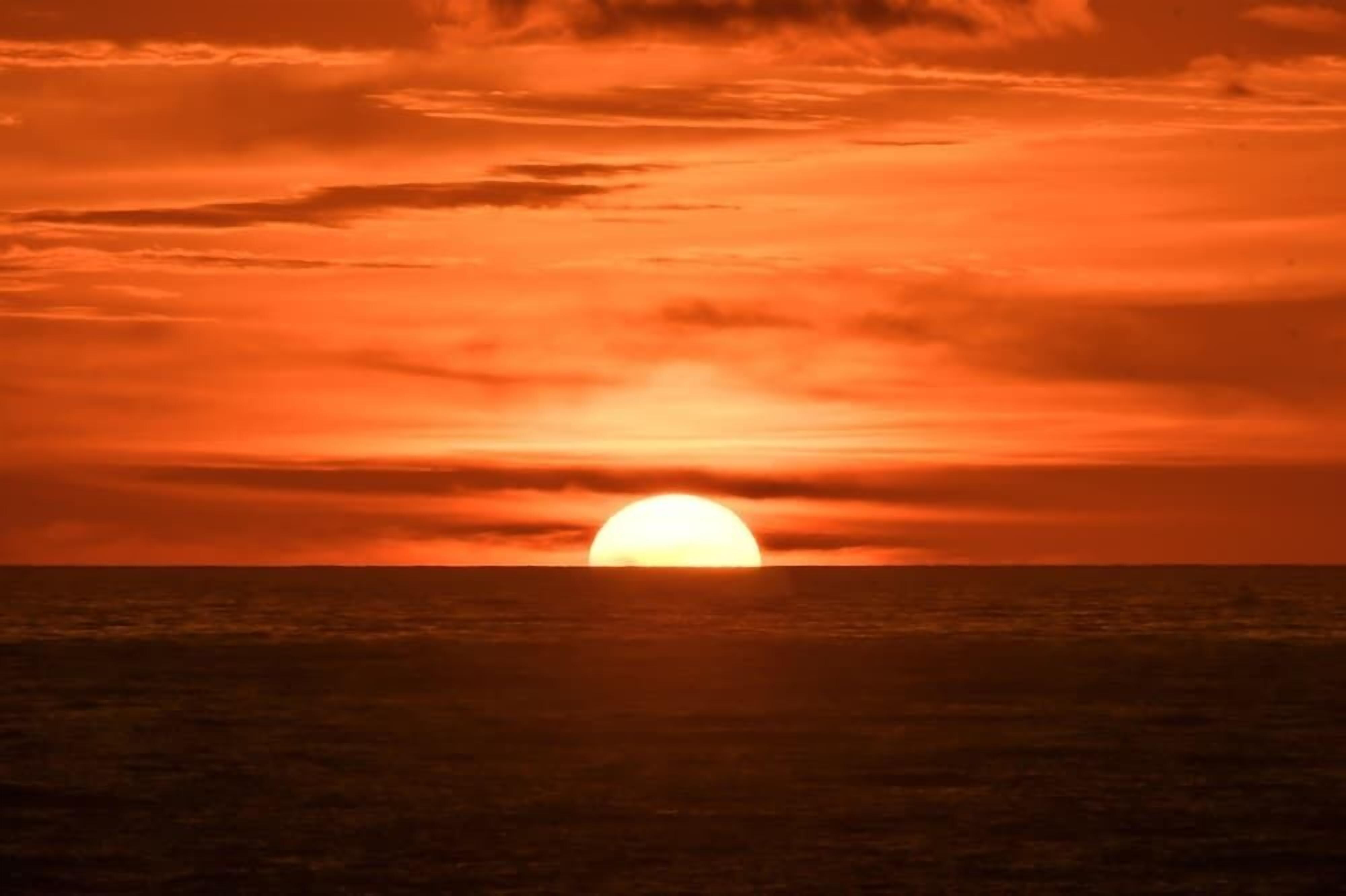 Ein Sonnenuntergang über dem Meer mit klarem Horizont.