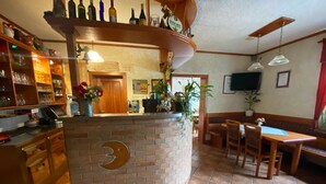 Un restaurant doté d’un comptoir incurv é en briques, de meubles en bois et d’un sol carrelé.