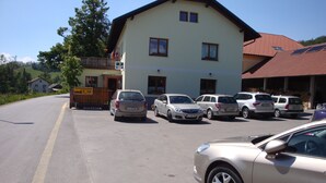 Un bâtiment doté d’un parking où sont stationnées plusieurs voitures.
