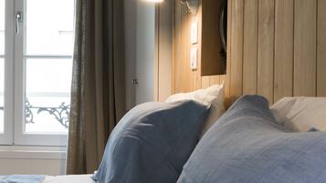 A bedroom with a wooden headboard, a bedside lamp, and a window with curtains.