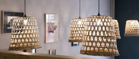 A modern interior with hanging woven light fixtures and framed artwork on the wall.