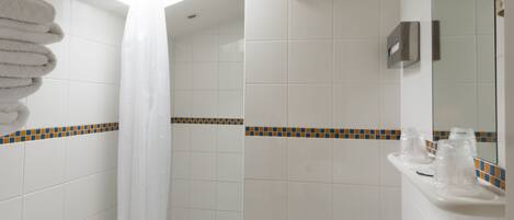 Un baño moderno con tragaluz, bañera, lavamanos e inodoro.