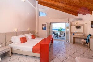 Una camera d'albergo moderna con un grande letto, una scrivania e un balcone vista mare.