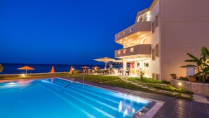 Un hotel con piscina, zona de estar al aire libre y vistas al mar.