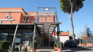 Entrada de un hotel con un letrero destacado que dice "Hotel Star" y un símbolo de estrella arriba.