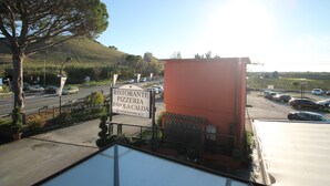 Señalización de un restaurante y hotel, un estacionamiento y una colina al fondo.