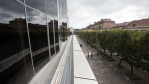 Un bâtiment moderne doté de grandes fenêtres en verre et d’une promenade piétonne.