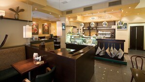 Un restaurant doté d’un bar, de tables et d’un comptoir où sont présentés les plats proposés à la carte.
