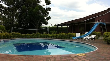 Una piscina al aire libre, tumbonas