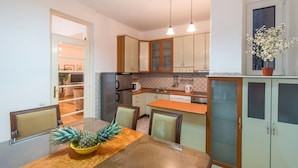 Una cocina con una mesa de comedor, sillas y una planta en maceta.