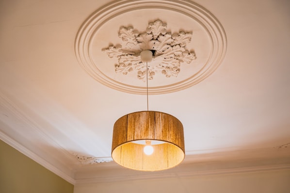 A ceiling with a decorative medallion and a hanging light fixture.