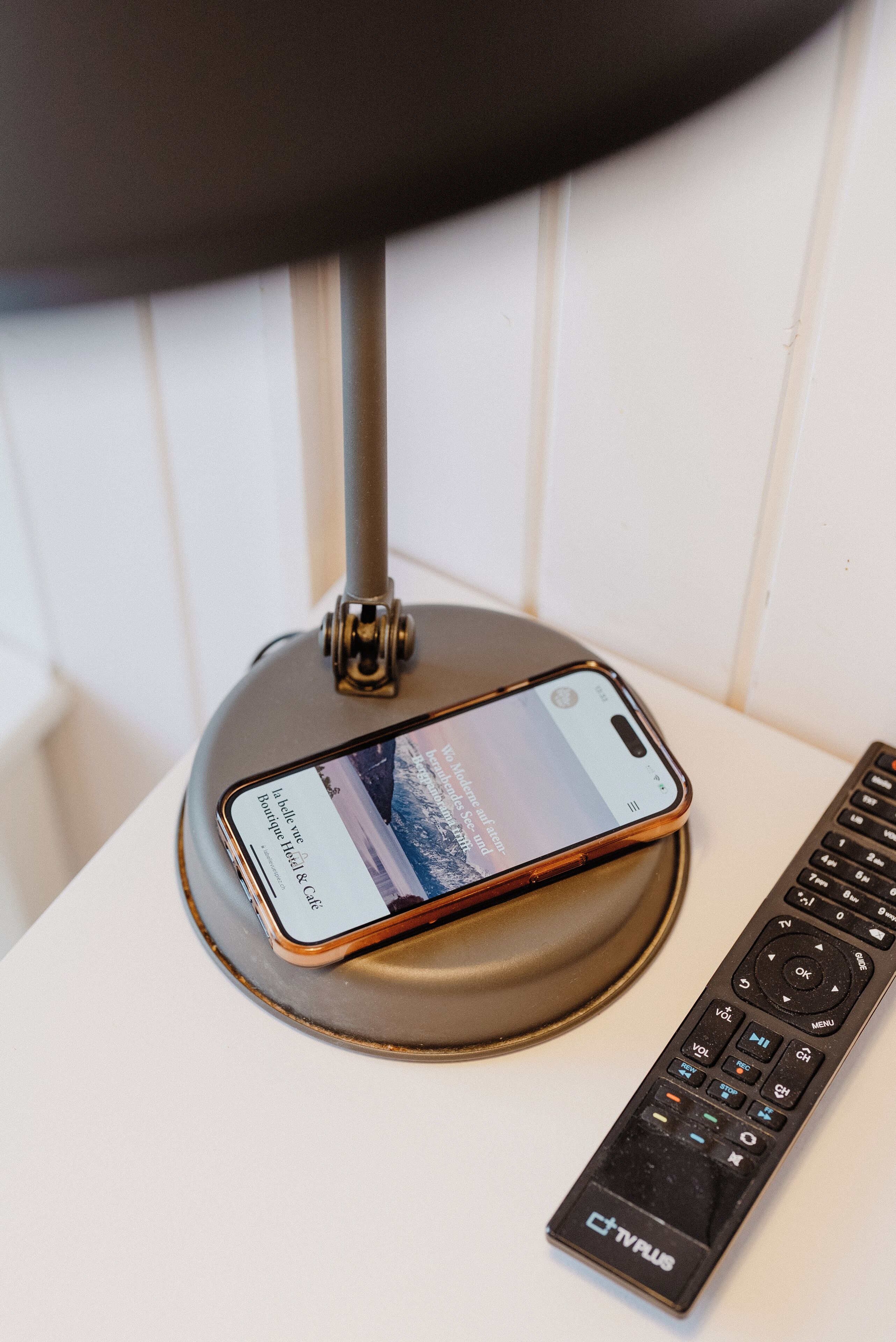 Um smartphone em um suporte com um controle remoto ao lado.