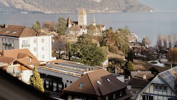 A view of a town with buildings, a church, and mountains in the background.