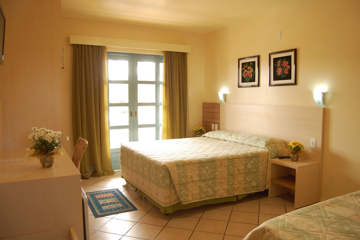 A bedroom with a bed, bedside tables, a desk, and a chair.