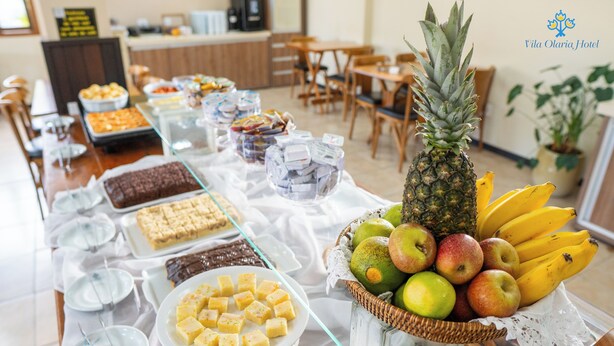 A buffet table with various food items including fruits, desserts, and beverages. - Vila Olaria Hotel (Penha)