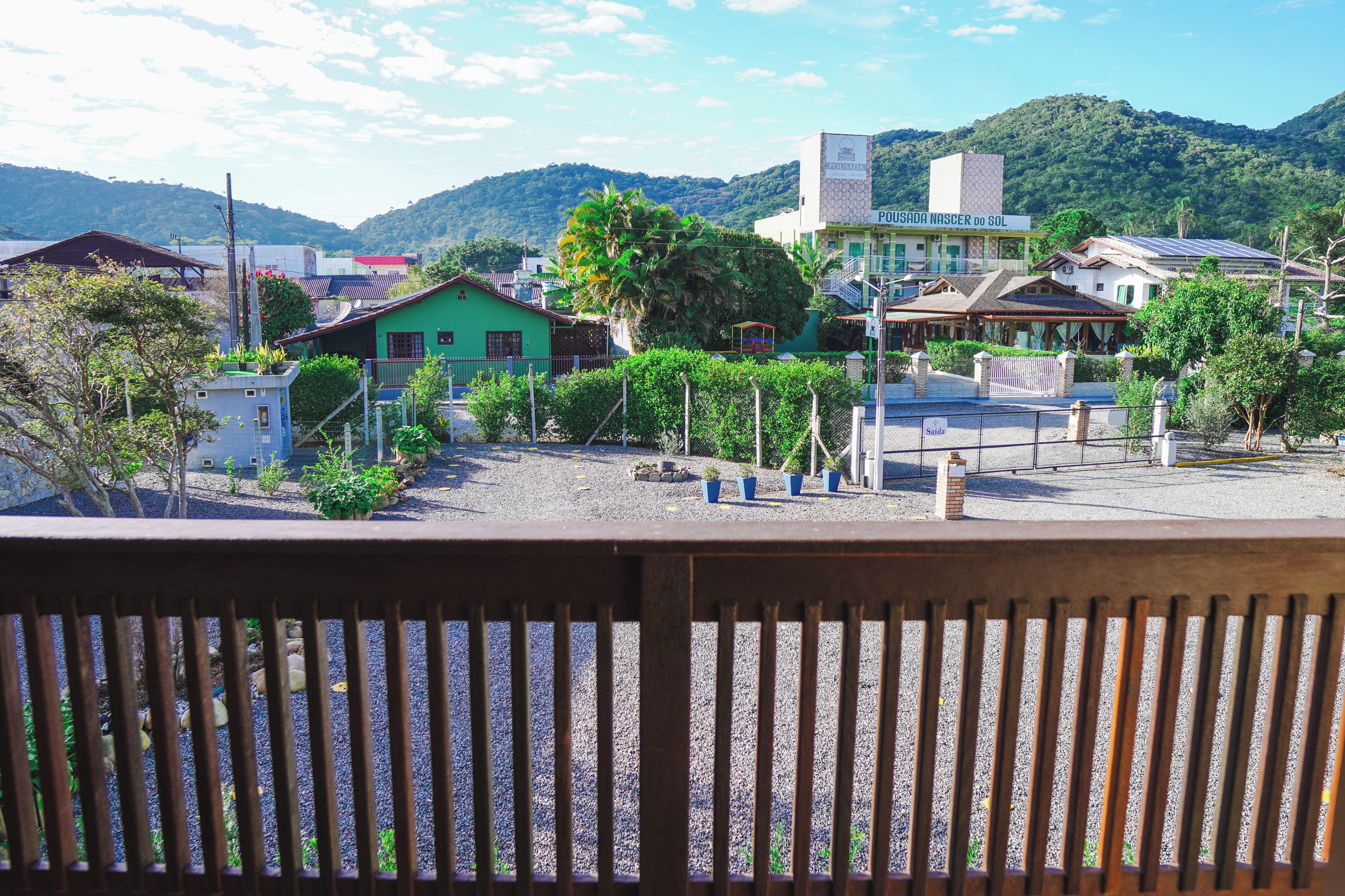 Bairro residencial com casas, parquinho e um edifício com placa.