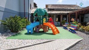 A children's play area with a slide, climbing structure, and benches. - Vila Olaria Hotel (Penha)